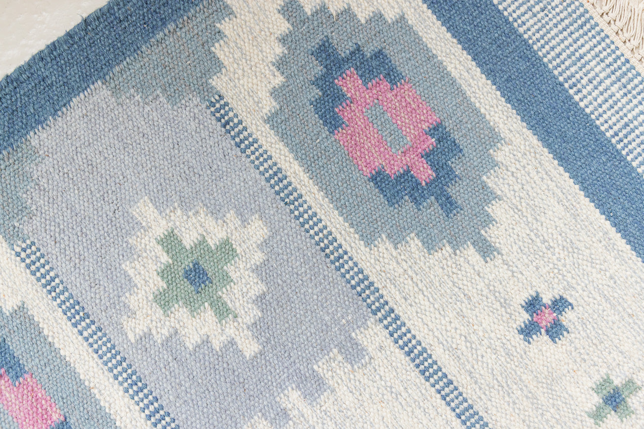 This rug shows beautiful tones of blue, this vintage kilim is featuring bold geometric design with hints of pink within the motifs in the carpet. 