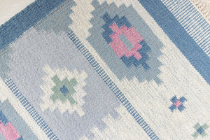 This rug shows beautiful tones of blue, this vintage kilim is featuring bold geometric design with hints of pink within the motifs in the carpet. 