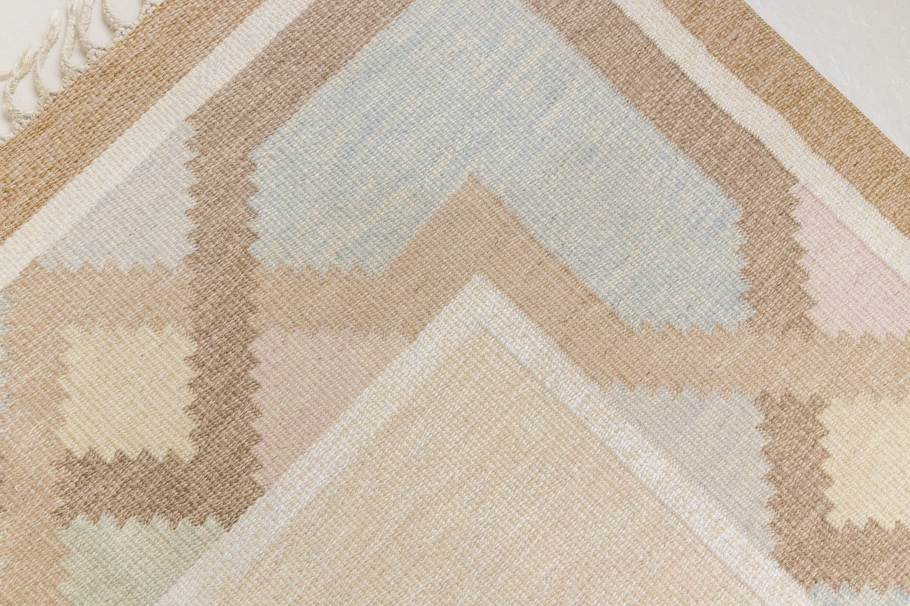 This is an original Swedish röllakan rug handwoven by the mid-century textile designer Anna Johanna Angström. Featuring a geometric patterned rug with pastel colors on a neutral background