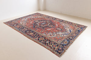 This a Vintage Persian Rug from Heriz in Persia. This hand woven Carpet features a lovely red ground with a central medallion design.