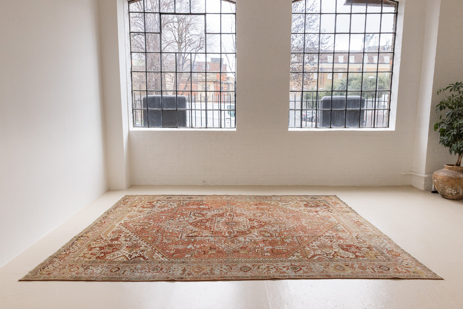 Lainey showcases a classic Heriz composition, centred around a striking medallion set against a soft rust-coloured field, complemented by a light khaki-toned border. Traditional palmette and floral motifs are interpreted through bold, geometric patterns.