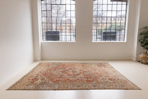 Lainey showcases a classic Heriz composition, centred around a striking medallion set against a soft rust-coloured field, complemented by a light khaki-toned border. Traditional palmette and floral motifs are interpreted through bold, geometric patterns.