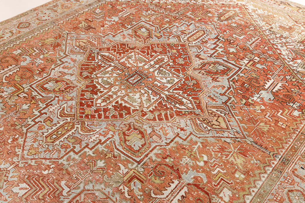 Lainey showcases a classic Heriz composition, centred around a striking medallion set against a soft rust-coloured field, complemented by a light khaki-toned border. Traditional palmette and floral motifs are interpreted through bold, geometric patterns.