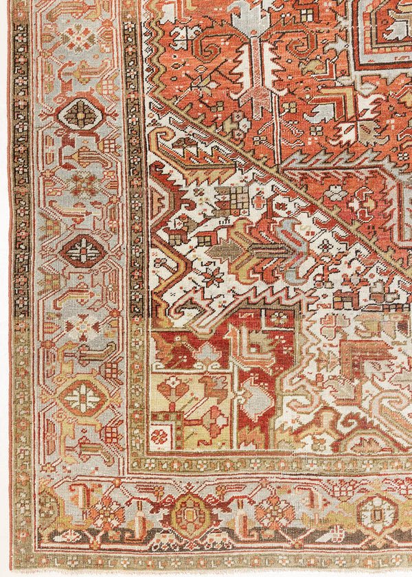 Lainey showcases a classic Heriz composition, centred around a striking medallion set against a soft rust-coloured field, complemented by a light khaki-toned border. Traditional palmette and floral motifs are interpreted through bold, geometric patterns.