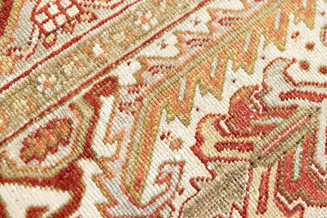Lainey showcases a classic Heriz composition, centred around a striking medallion set against a soft rust-coloured field, complemented by a light khaki-toned border. Traditional palmette and floral motifs are interpreted through bold, geometric patterns.