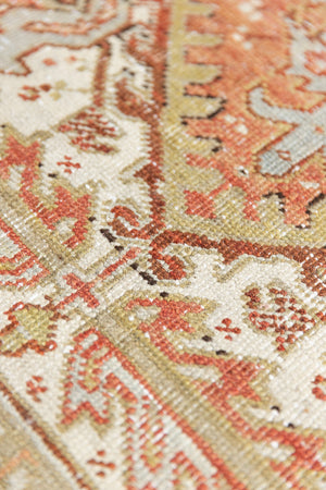 Lainey showcases a classic Heriz composition, centred around a striking medallion set against a soft rust-coloured field, complemented by a light khaki-toned border. Traditional palmette and floral motifs are interpreted through bold, geometric patterns.