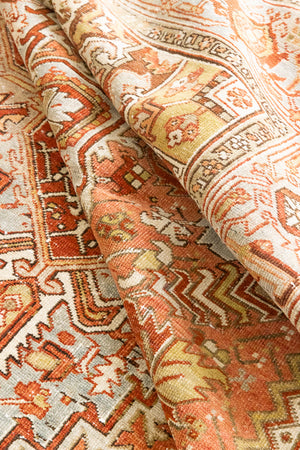 Lainey showcases a classic Heriz composition, centred around a striking medallion set against a soft rust-coloured field, complemented by a light khaki-toned border. Traditional palmette and floral motifs are interpreted through bold, geometric patterns.