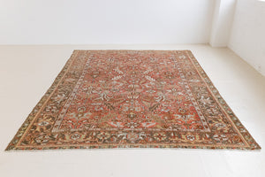 This a Vintage Persian Rug from Heriz in Persia. This hand woven Carpet features a lovely rust red and khaki green colour palette with a central medallion design.