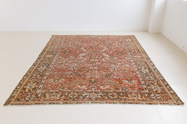 This a Vintage Persian Rug from Heriz in Persia. This hand woven Carpet features a lovely rust red and khaki green colour palette with a central medallion design.