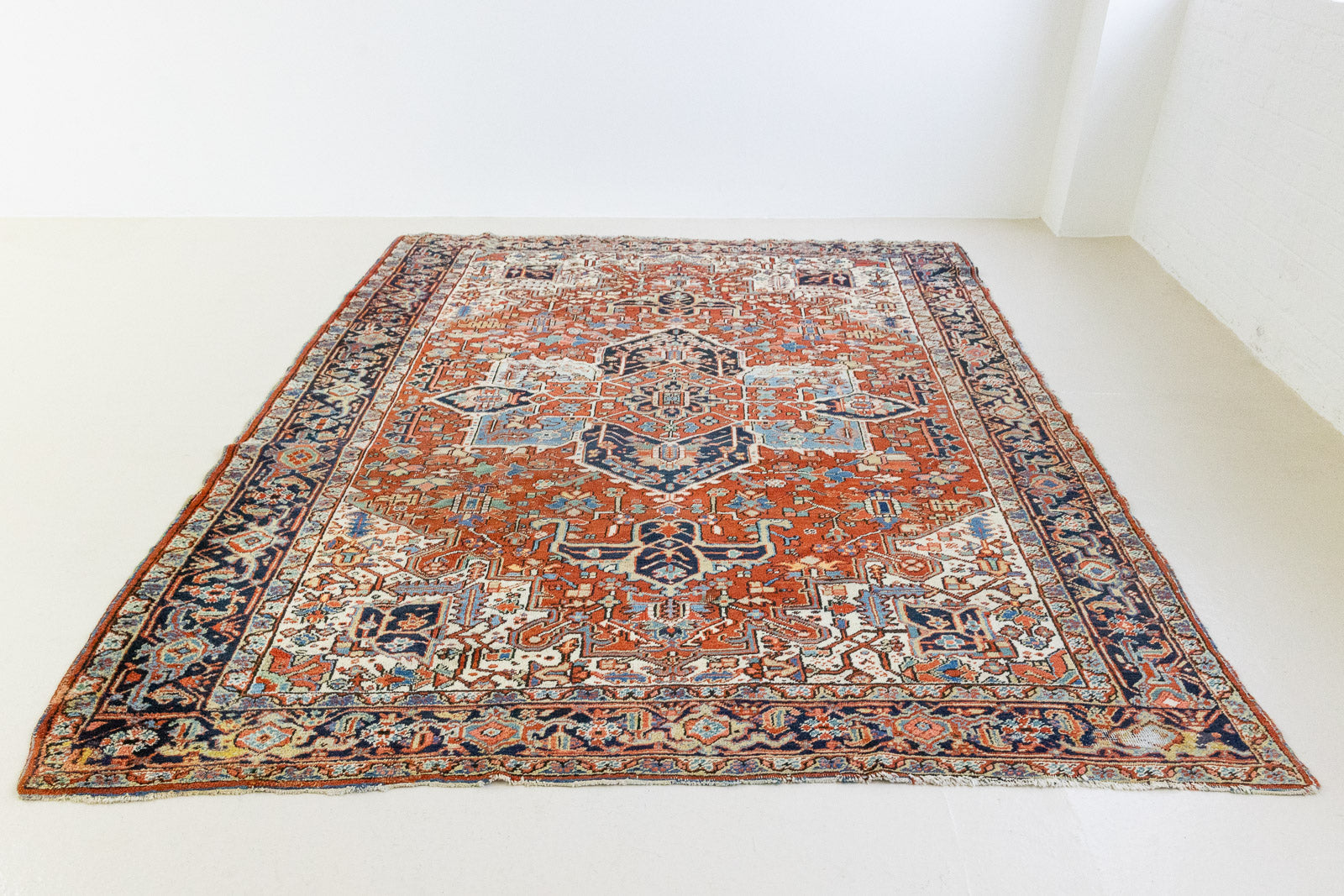 This a Vintage Persian Rug from Heriz in Persia. This hand woven Carpet features a lovely red ground with a central medallion design.