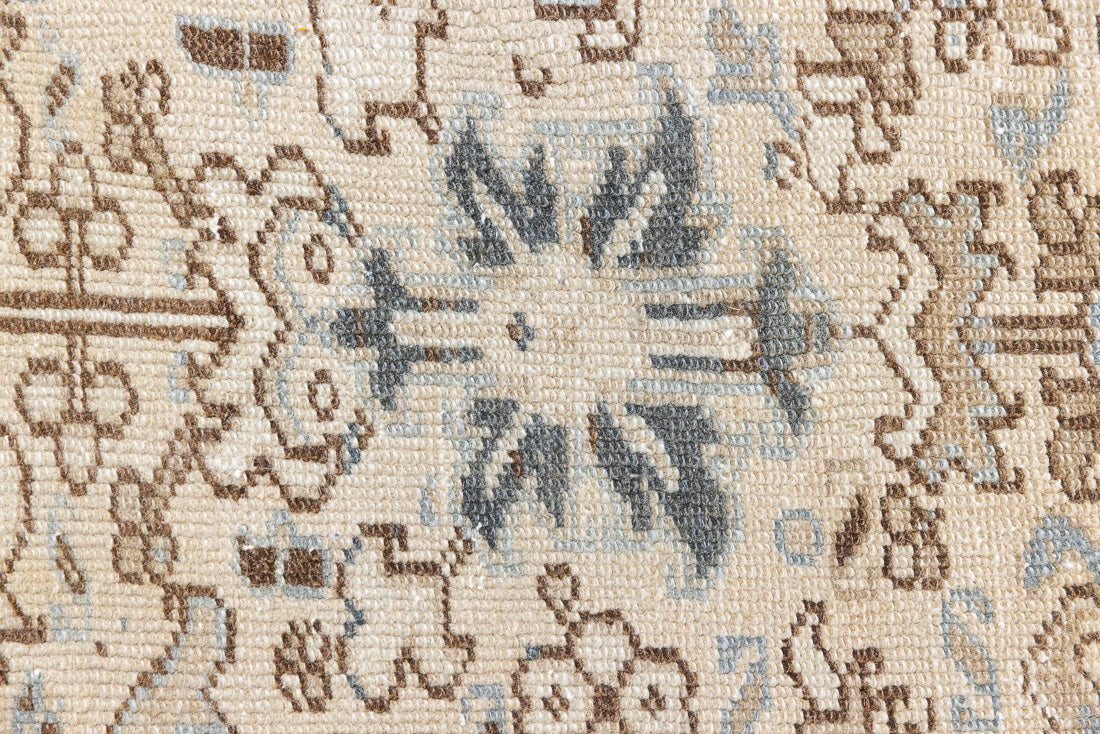 The Portia rug features an intricate all over Heriz design comprised of floral and palmette motifs set against a taupe ground and muted blue toned boarder. A beautiful antique carpet.
