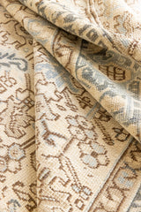 The Portia rug features an intricate all over Heriz design comprised of floral and palmette motifs set against a taupe ground and muted blue toned boarder. A beautiful antique carpet.