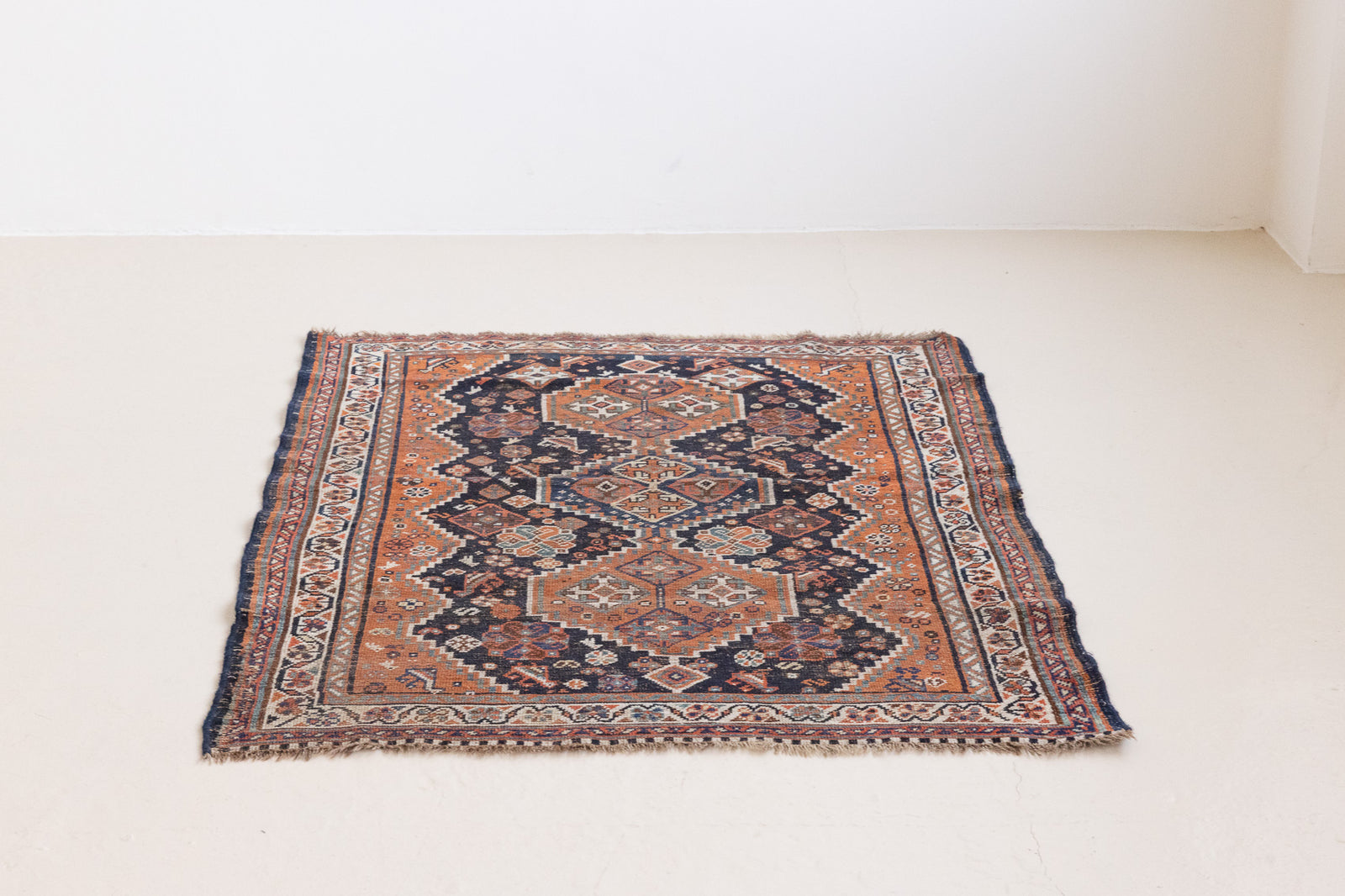 This a Vintage Persian Rug from Quahqai in Persia. This hand woven Carpet features a red ground with an all over nature themed design.