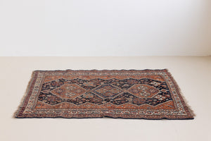 This a Vintage Persian Rug from Quahqai in Persia. This hand woven Carpet features a red ground with an all over nature themed design.