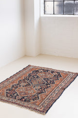 This a Vintage Persian Rug from Quahqai in Persia. This hand woven Carpet features a red ground with an all over nature themed design.