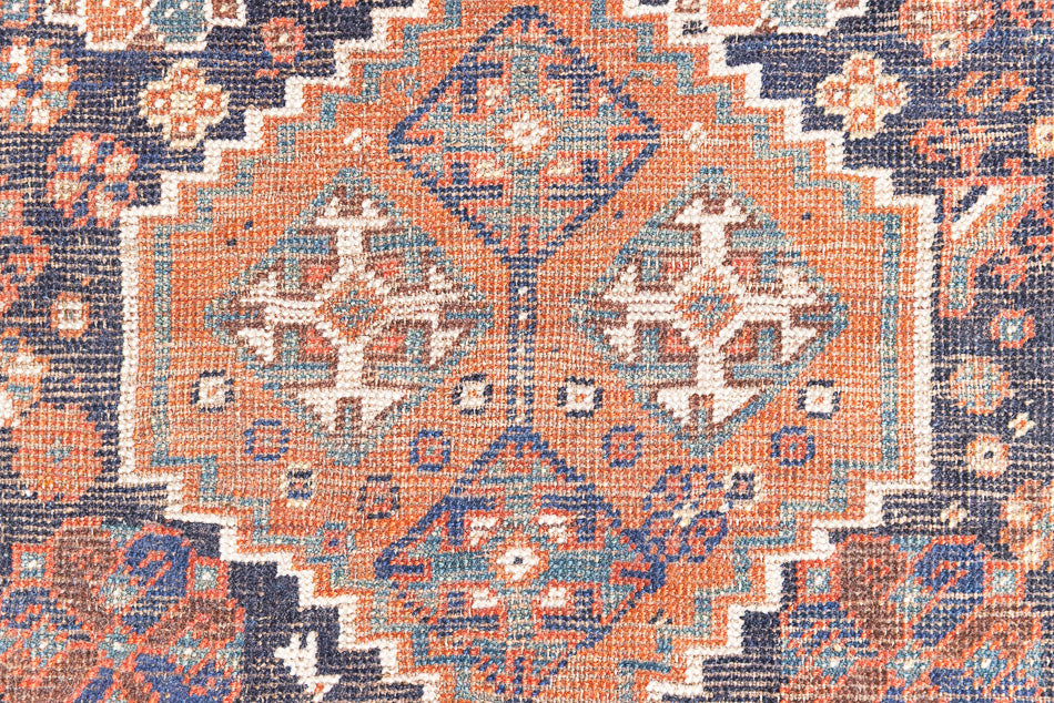 This a Vintage Persian Rug from Quahqai in Persia. This hand woven Carpet features a red ground with an all over nature themed design.
