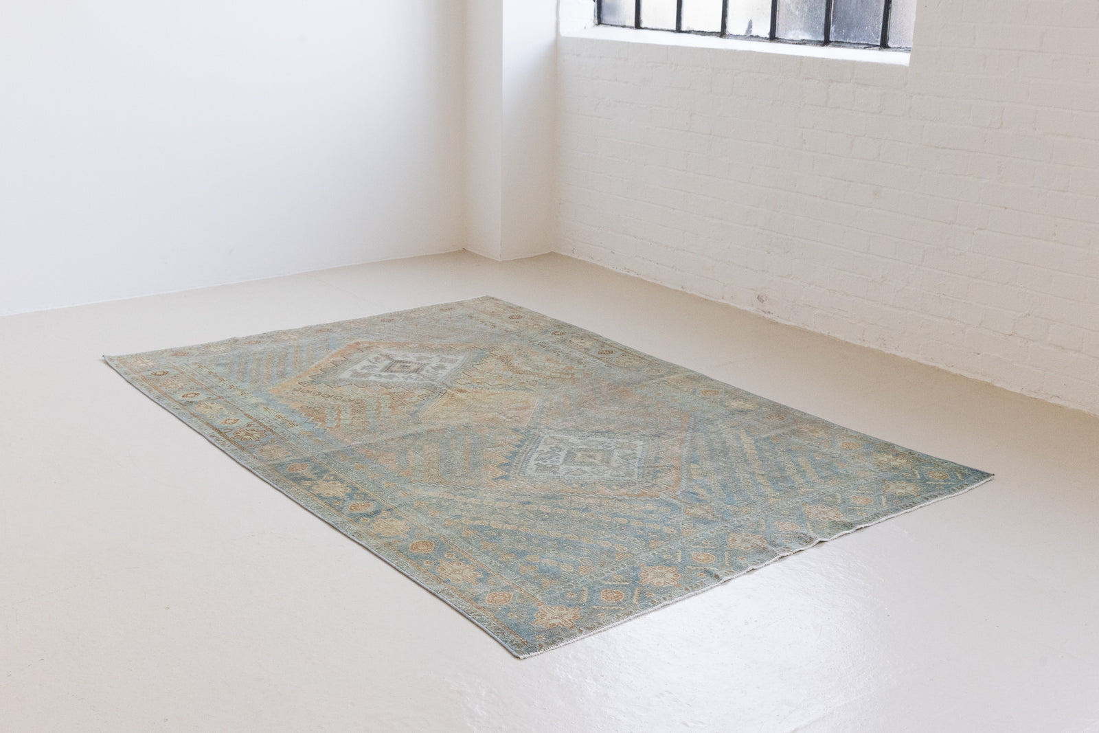 This is an Vintage Qashqai nomadic rug featuring a soft natural blue and orange with beautifully intricate designs within this handwoven carpet, a repeating boteh pattern frames the central diamond motifs.