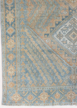This is an Vintage Qashqai nomadic rug featuring a soft natural blue and orange with beautifully intricate designs within this handwoven carpet, a repeating boteh pattern frames the central diamond motifs.