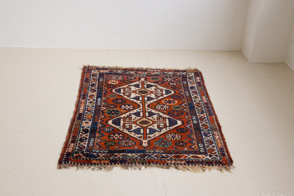 Gigi features a striking central diamond medallion, a classic motif in Qashqai weaving, framed by a repeating floral and gul pattern and a boteh patterned boarder.