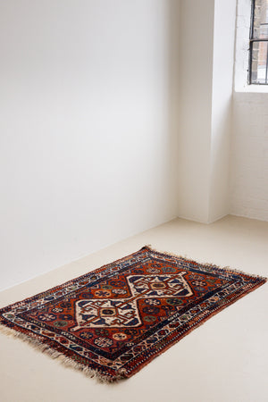 Gigi features a striking central diamond medallion, a classic motif in Qashqai weaving, framed by a repeating floral and gul pattern and a boteh patterned boarder.