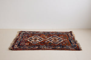 Gigi features a striking central diamond medallion, a classic motif in Qashqai weaving, framed by a repeating floral and gul pattern and a boteh patterned boarder.