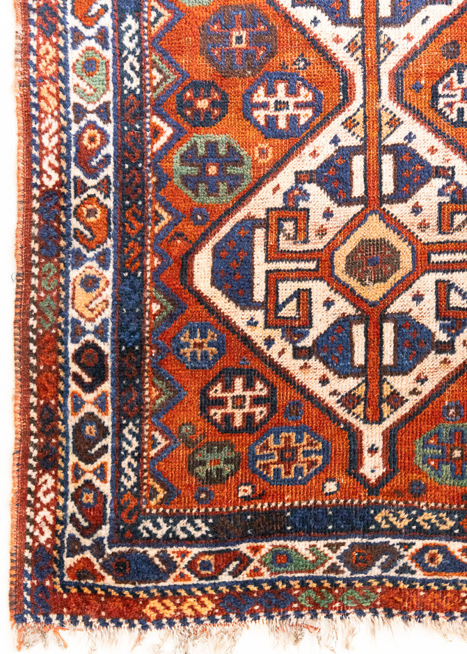 Gigi features a striking central diamond medallion, a classic motif in Qashqai weaving, framed by a repeating floral and gul pattern and a boteh patterned boarder.