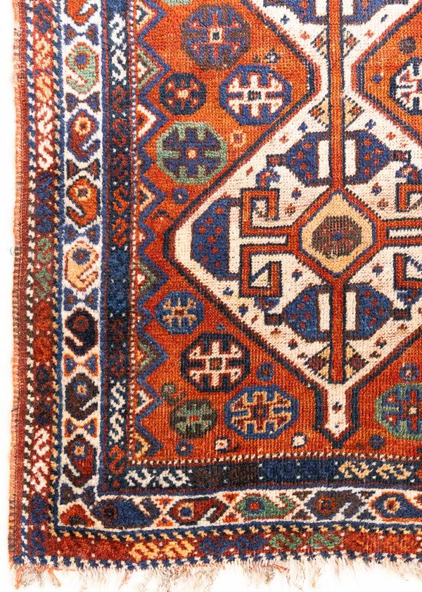 Gigi features a striking central diamond medallion, a classic motif in Qashqai weaving, framed by a repeating floral and gul pattern and a boteh patterned boarder.