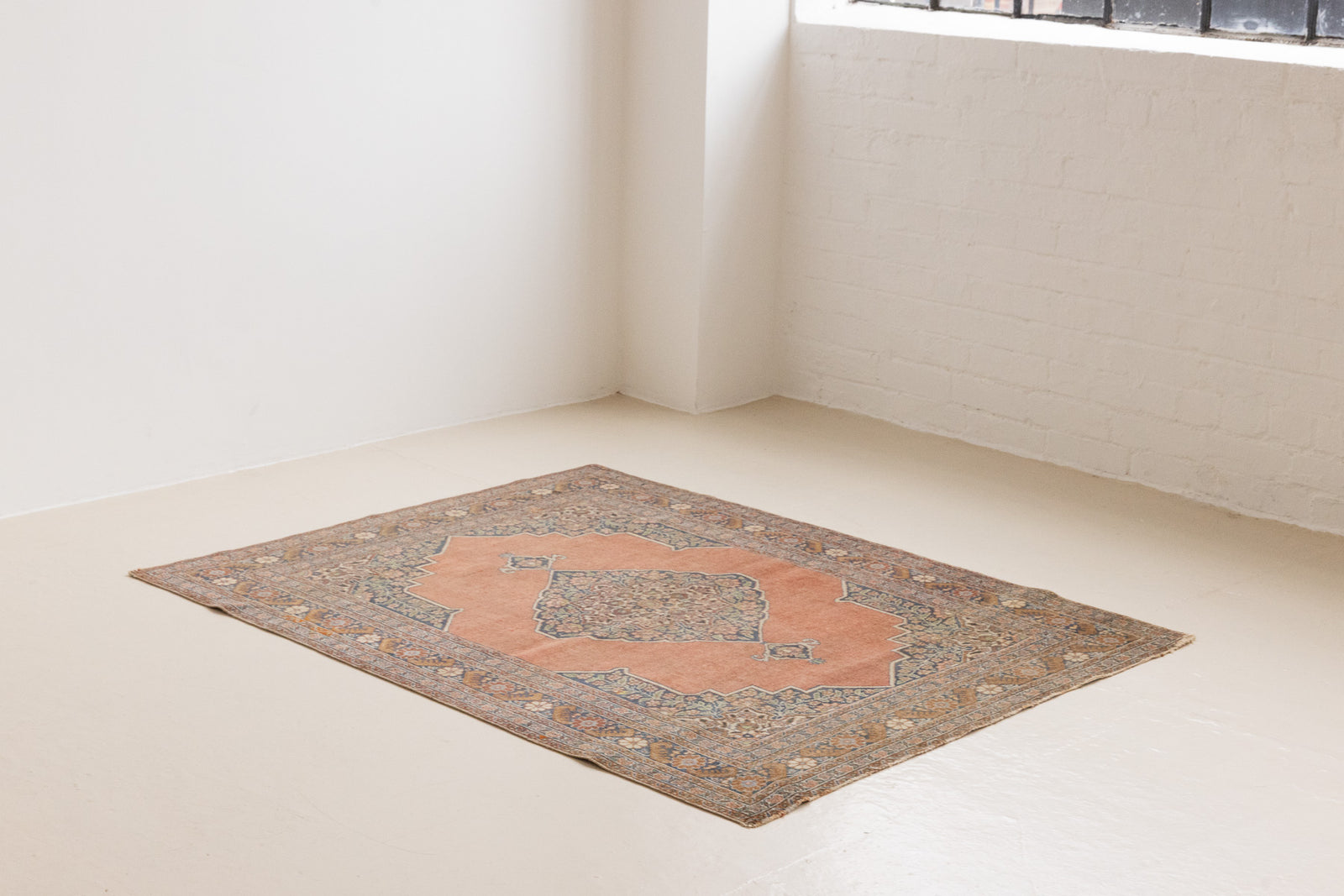 Selma is a beautiful antique Persian Tabriz rug with a soft yet bold coral colour palette and a stunning abrash and patina with a lovely central medallion.