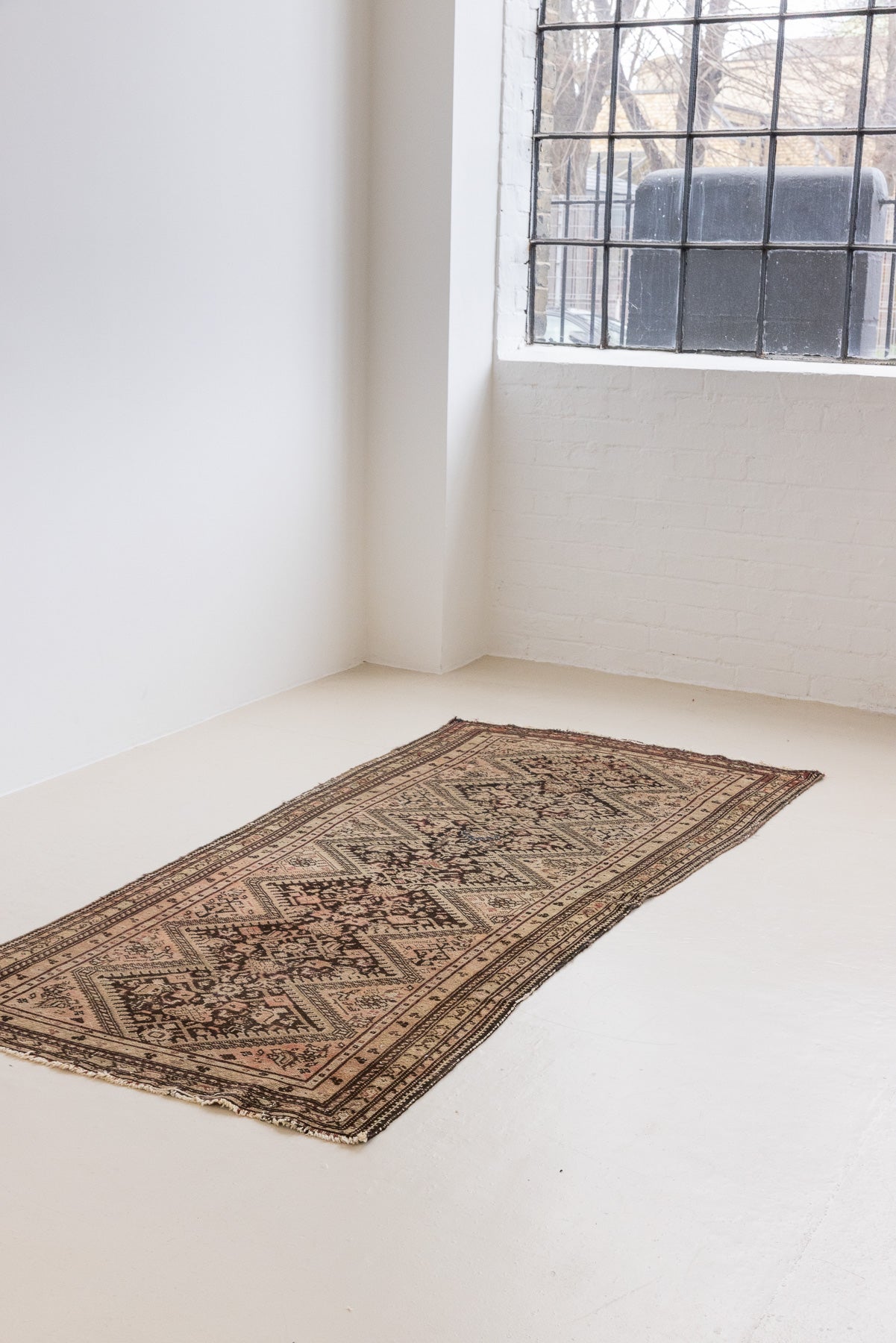 This a Vintage Persian Rug from Qashqai in Persia. This hand woven Carpet features a lovely pink and dark brown colour palette with a central medallion design.