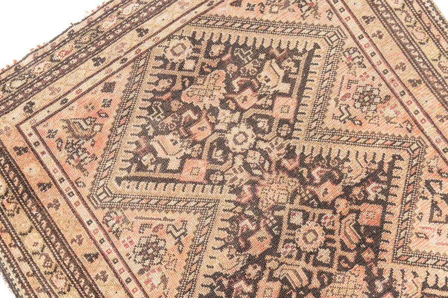 This a Vintage Persian Rug from Qashqai in Persia. This hand woven Carpet features a lovely pink and dark brown colour palette with a central medallion design.