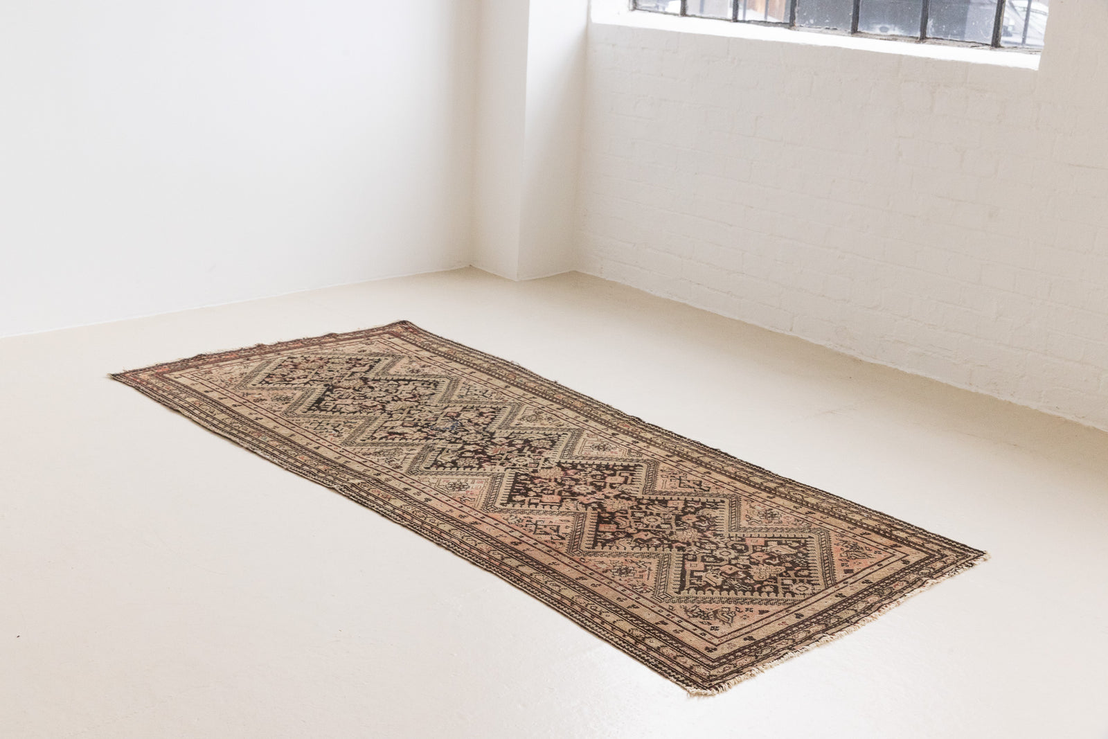 This a Vintage Persian Rug from Qashqai in Persia. This hand woven Carpet features a lovely pink and dark brown colour palette with a central medallion design.