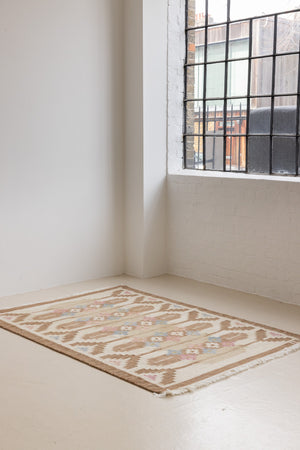 Maja is an original röllakan rug handwoven by the internationally renowned textile designer Ingegerd Silow. This vintage rug features geometric designs in brown, beige, pink and blue on a light beige ground.