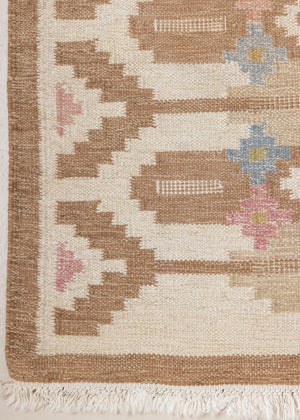 Maja is an original röllakan rug handwoven by the internationally renowned textile designer Ingegerd Silow. This vintage rug features geometric designs in brown, beige, pink and blue on a light beige ground.
