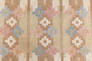 Maja is an original röllakan rug handwoven by the internationally renowned textile designer Ingegerd Silow. This vintage rug features geometric designs in brown, beige, pink and blue on a light beige ground.