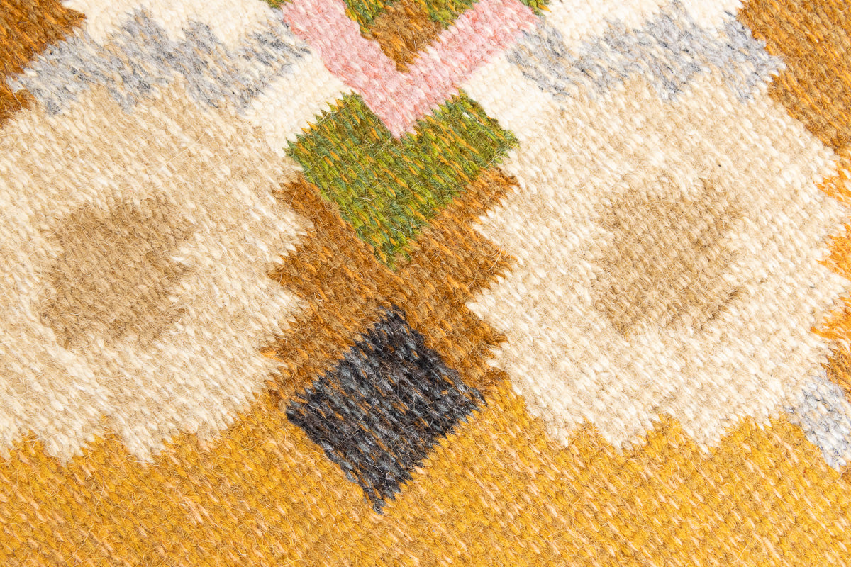 Kaia is a signed vintage Swedish flatweave rug by Ingegerd Silow, featuring a warm ochre field centred framed by stylised florals