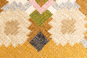 Kaia is a signed vintage Swedish flatweave rug by Ingegerd Silow, featuring a warm ochre field centred framed by stylised florals