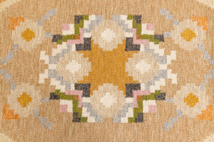 Kaia is a signed vintage Swedish flatweave rug by Ingegerd Silow, featuring a warm ochre field centred framed by stylised florals