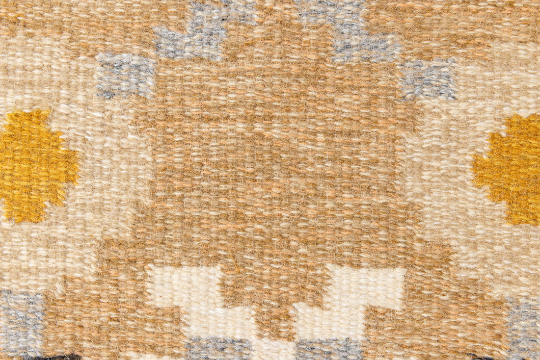Kaia is a signed vintage Swedish flatweave rug by Ingegerd Silow, featuring a warm ochre field centred framed by stylised florals