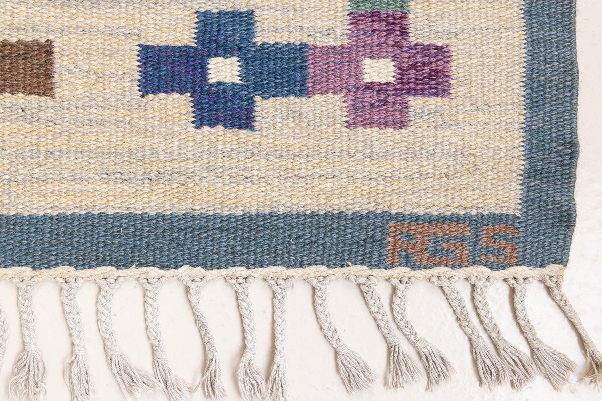 Lumi is a signed vintage Swedish flatweave rug by Anna-Greta Sjöqvist, featuring a calm blue field framed by ivory borders and delicate geometric motifs. Handwoven in wool using the traditional rölakan technique.