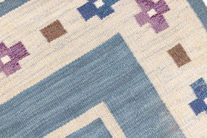Lumi is a signed vintage Swedish flatweave rug by Anna-Greta Sjöqvist, featuring a calm blue field framed by ivory borders and delicate geometric motifs. Handwoven in wool using the traditional rölakan technique.
