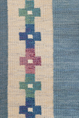 Lumi is a signed vintage Swedish flatweave rug by Anna-Greta Sjöqvist, featuring a calm blue field framed by ivory borders and delicate geometric motifs. Handwoven in wool using the traditional rölakan technique.
