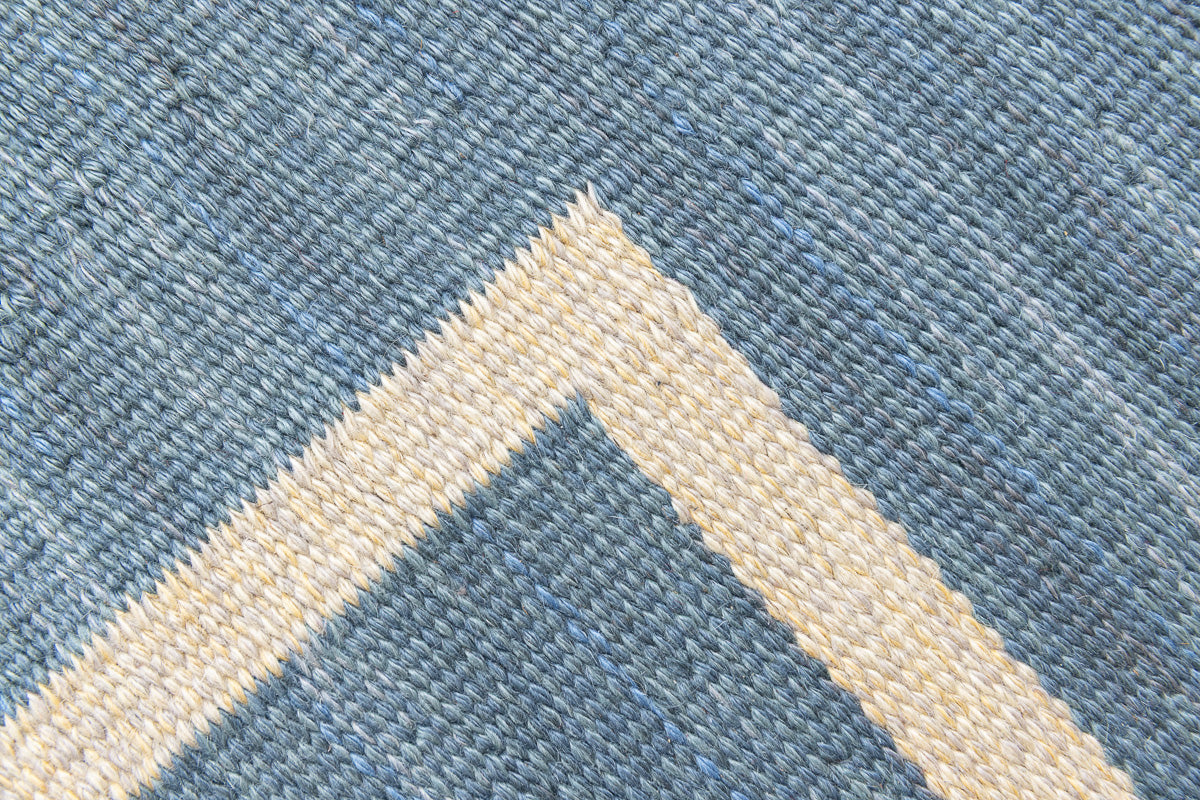 Lumi is a signed vintage Swedish flatweave rug by Anna-Greta Sjöqvist, featuring a calm blue field framed by ivory borders and delicate geometric motifs. Handwoven in wool using the traditional rölakan technique.