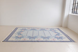 Hallie is an large original röllakan flat weave from the 1960s. This rug shows beautiful tones of blue, featuring bold geometric design with hints of pink within the motifs.