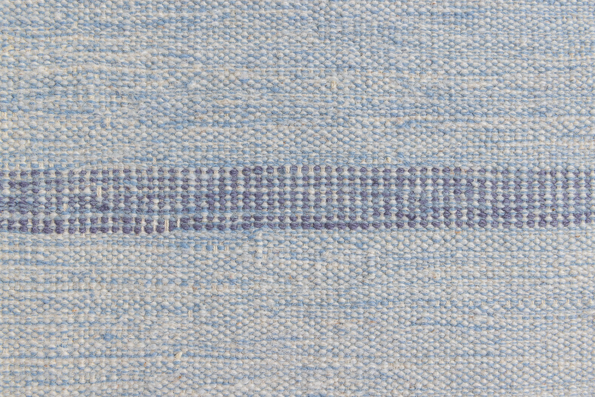 Hallie is an large original röllakan flat weave from the 1960s. This rug shows beautiful tones of blue, featuring bold geometric design with hints of pink within the motifs.