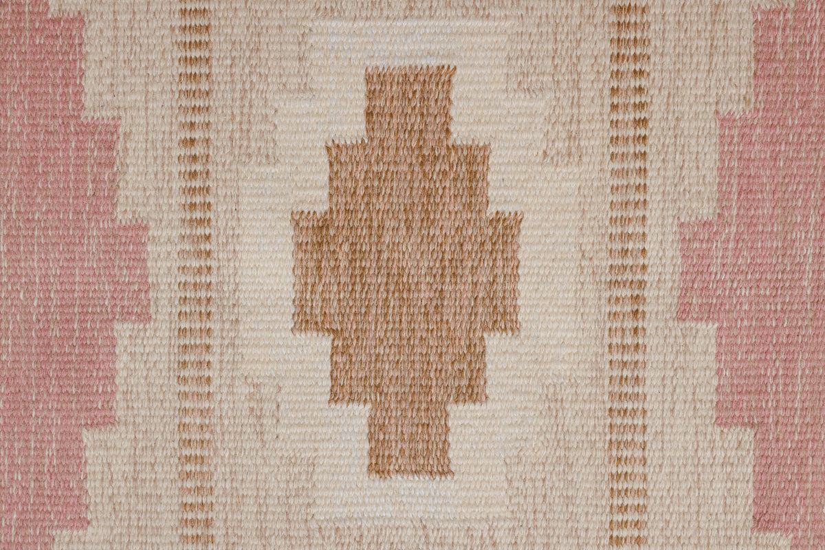 Trina is an original Swedish röllakan rug handwoven by the mid-century textile designer Anna Johanna Angström. This vintage rug features geometric designs in pink, blue, and brown on a beige ground.