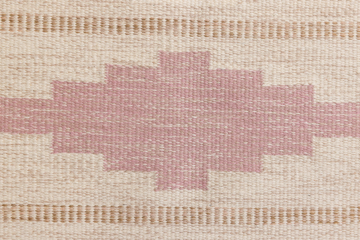 Trina is an original Swedish röllakan rug handwoven by the mid-century textile designer Anna Johanna Angström. This vintage rug features geometric designs in pink, blue, and brown on a beige ground.