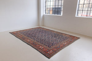 This a Vintage Persian Rug from Heriz in Persia. This hand woven Carpet features a lovely rust red and khaki green colour palette with a central medallion design.