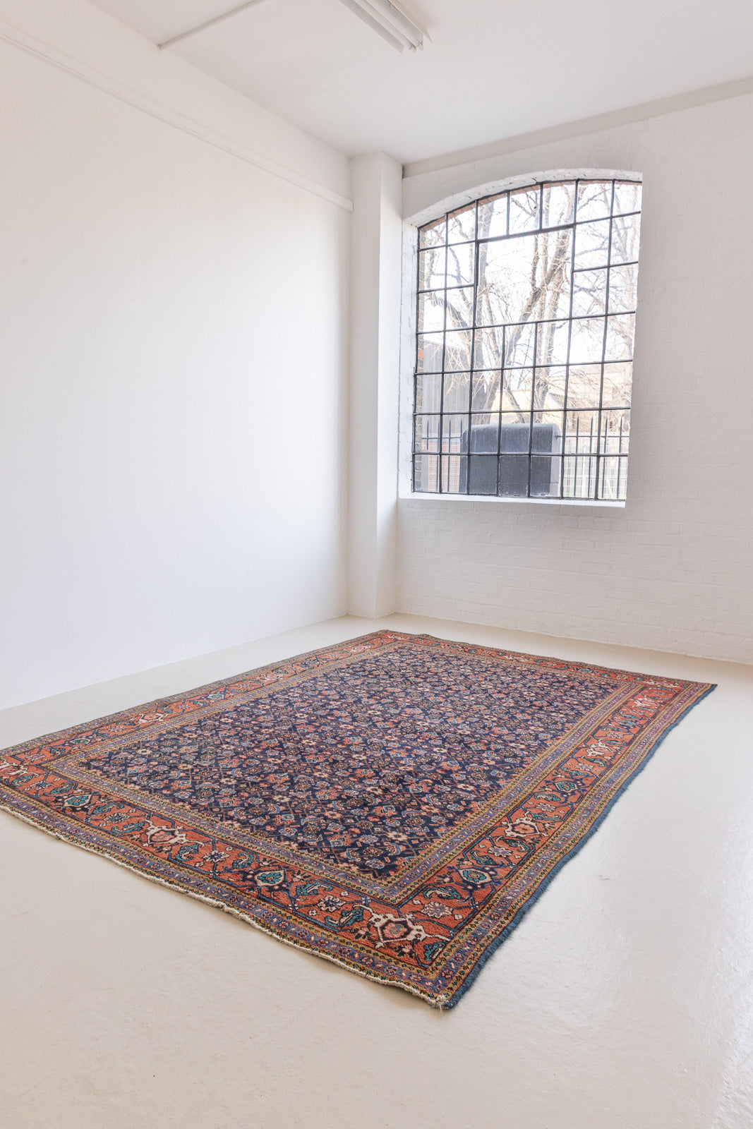 This a Vintage Persian Rug from Heriz in Persia. This hand woven Carpet features a lovely rust red and khaki green colour palette with a central medallion design.