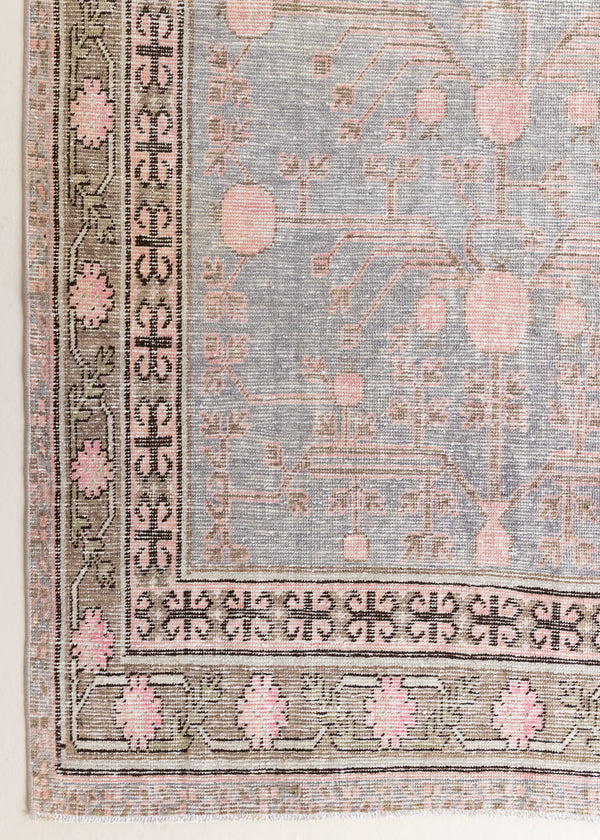 An antique Khotan rug with a soft blue field and an all-over pomegranate design