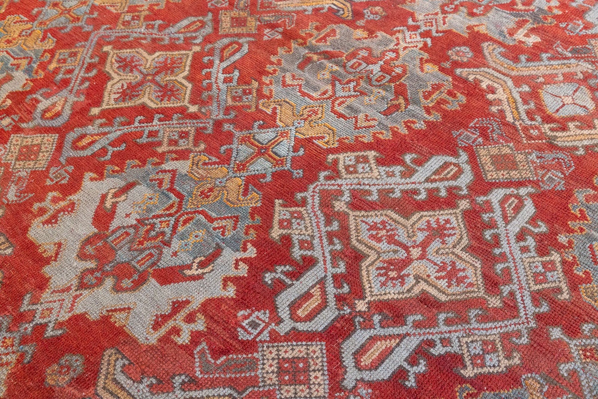 Early 20th-century antique Turkish carpet in red, blue and ivory, a large handwoven Oushak rug by Ourika London